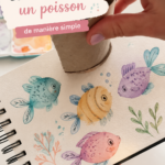 Poisson coloré peint à la main, exposé sur un mur décoratif.